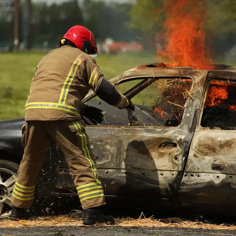 Trainee firefighter attending to flaming car